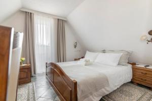 a bedroom with a large white bed and a window at Jagodic Garni Hotel in Cerklje na Gorenjskem