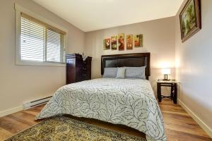 a bedroom with a large bed and a window at Rodee Homestay in West Kelowna