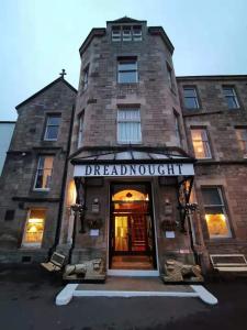 a brick building with the entrance to the dreadnought stair at Dreadnought Hotel in Callander