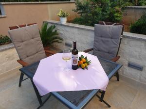 una mesa con una botella de vino y una copa en MARILU en Korčula