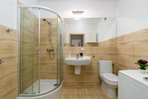 łazienka z prysznicem, toaletą i umywalką w obiekcie Sleepway Apartments - Garbary 95-78 w Poznaniu +12 zdjęć