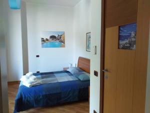 a bedroom with a bed with a blue comforter at Il Saretto in Sarno