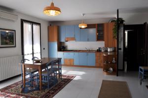 a kitchen with blue cabinets and a table and chairs at Casa Marisa in Lovere