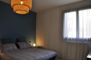 - une chambre avec un lit, une fenêtre et un lustre dans l'établissement Casa Marisa, à Lovere