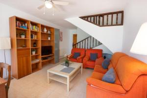 a living room with two orange couches and a staircase at Casa María in Nerja