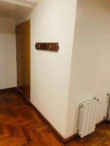 una habitación con una pared blanca con una maleta en la pared en Hotel Petit en Córdoba
