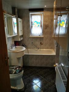 a bathroom with a tub and a toilet and a sink at "Elbparadies" Ferienhaus am Niegripper See mit Pool in Burg bei Magdeburg