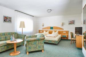 pokój hotelowy z łóżkiem i kanapą w obiekcie Gasthof Weichlein w mieście Wachenroth
