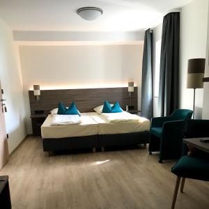 um quarto de hotel com uma cama com almofadas azuis em Gasthof Weichlein em Wachenroth