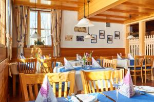 een restaurant met tafels en stoelen met blauwe tafelkleden bij Gasthof Weichlein in Wachenroth