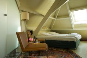 um quarto com uma cama, uma cadeira e uma janela em Hotel Restaurant Oortjeshekken em Ooij