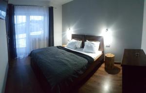 um quarto com uma cama com almofadas brancas e uma janela em Villa Krzesanica em Czarna Góra