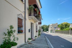 una strada vuota con un edificio con fiori alla finestra di Villa Margherita Crespino a Crespino