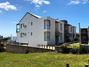 una casa blanca con un cartel delante en Brisas del Rivero, en Punta del Diablo