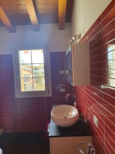 La salle de bains est pourvue d'un lavabo et d'une fenêtre. dans l'établissement Happy house villotta, à Chions