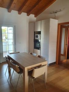 a dining room table with chairs and a kitchen at Happy house villotta in Chions