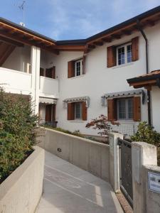 a white house with a gate and a driveway at Happy house villotta in Chions