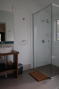 a bathroom with a glass shower and a sink at Southern Sky Glamping in Mount Tamborine