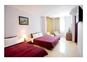 Cette chambre comprend deux lits et une télévision. dans l'établissement Dai A Hotel, à Đà Nẵng