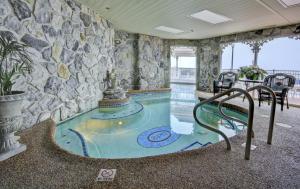 una piscina coperta in una stanza con un muro di pietra di Boardwalk Plaza Hotel a Rehoboth Beach