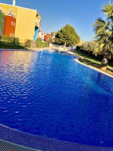 una grande piscina blu accanto a un edificio di piso Nata with private Terrace Lounge 75m2 a El Verger