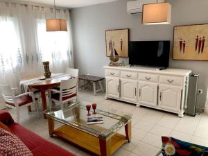 un soggiorno con TV, tavolo e divano di piso Nata with private Terrace Lounge 75m2 a El Verger