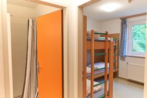 a room with a bunk bed and a refrigerator at Hostel Hütteldorf in Vienna