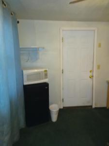a small kitchen with a microwave and a door at Bryce Canyon Motel in Panguitch