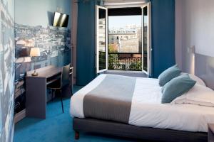 a bedroom with a bed and a desk and a window at Hôtel Odessa Montparnasse in Paris
