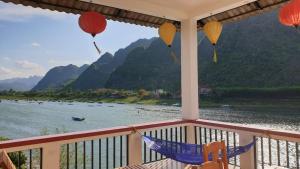 a balcony with a view of a river and mountains at Funny Monkeys Homestay in Phong Nha