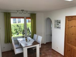 a dining room with a table and chairs and a window at Haus Seestern mit Strandkorb inkl in Göhren