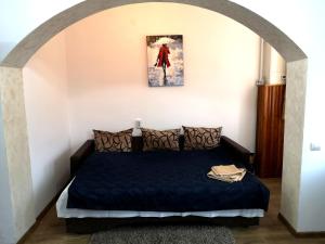 a bedroom with a black bed with a painting on the wall at Clemence Guesthouse in Braşov