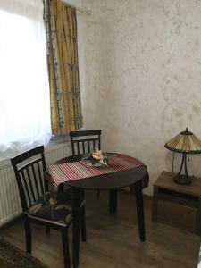 Una mesa y sillas en una habitación con ventana. en Clemence Guesthouse, en Brasov