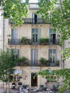 personnes assises à des tables devant un bâtiment dans l'établissement Hotel du Palais, à Montpellier