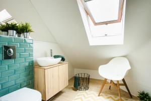 łazienka z umywalką i krzesłem w obiekcie V10 Apartment w mieście Pecz +11 zdjęć