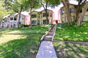 Un edificio con árboles y una acera delante. en Comal River Oasis, en New Braunfels