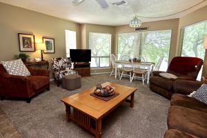 Una sala de estar con sofás y una mesa. en Comal River Oasis, en New Braunfels