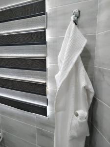 a white robe hanging on a towel rack in a bathroom at Home Boutique Hotel in Tashkent