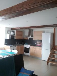 a kitchen with a white refrigerator and wooden cabinets at Les petites Fourches in Saint-Brisson