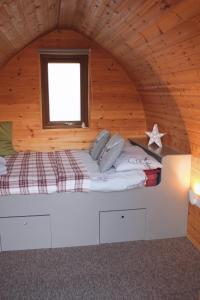 a bed in a wooden room with a window at Howe of Torbeg in Ballater
