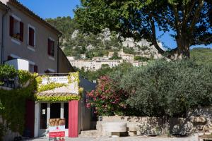 a building with a red door and a tree at Hotellerie du Domaine de Cabasse in Séguret