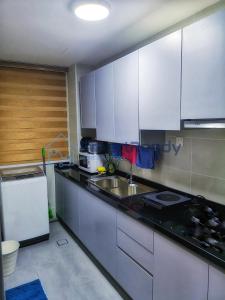 uma cozinha com um lavatório e uma bancada em Residences at Daya by SR Home em Johor Bahru