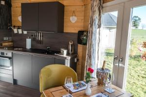 a kitchen with a table and chairs and a sink at Dunroamin Lodges in Drymen
