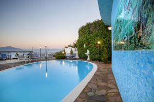 een groot zwembad naast een gebouw bij Amore Rentals - Villa Bianca in Sorrento