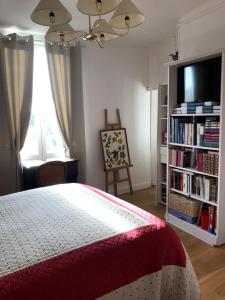 a bedroom with a bed and a book shelf with books at L'atelier de Jocelyne in Beuzeville