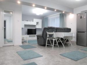 ein Wohnzimmer mit einem Sofa und einem Tisch sowie eine Küche in der Unterkunft Apartament Sarra in Târgovişte