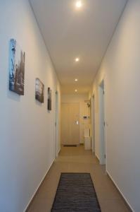 un couloir aux murs blancs et un couloir avec un tapis dans l'établissement What a Life! Apartment, à Nazaré