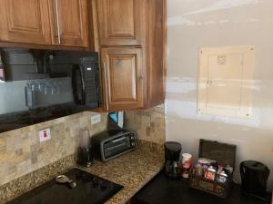 a kitchen with a counter top with a microwave at RAIROYALE AT SAND CASTLES in Ocho Rios