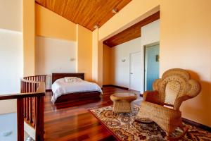 a room with a bed, chair, table and a window at Lake Arenal Condos in Naranjos Agrios