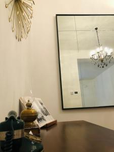 a dining room table with a mirror and a lamp at Eufemia27 in Verona